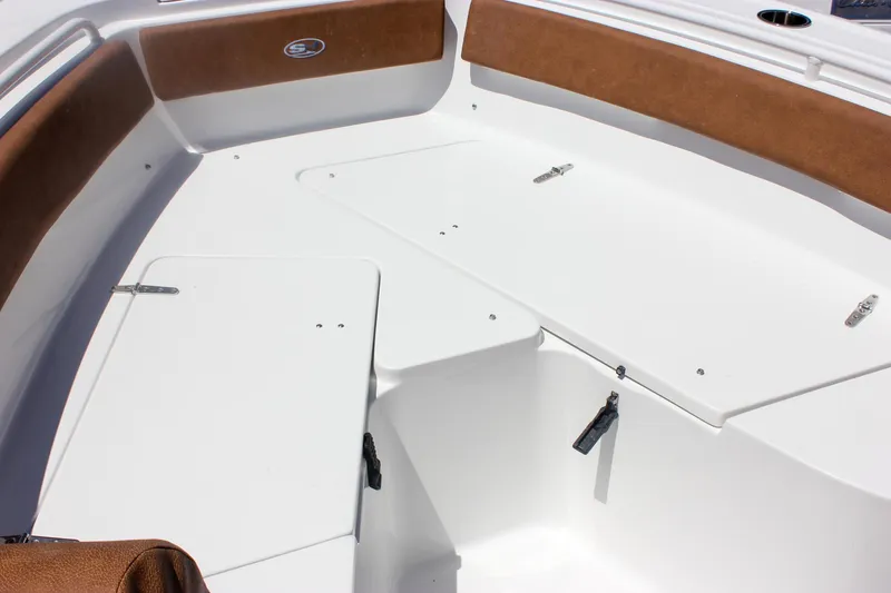 Slide: The Image of 2026 Sea Hunt Ultra 245 SE boat interior with white deck and brown seating. - 23