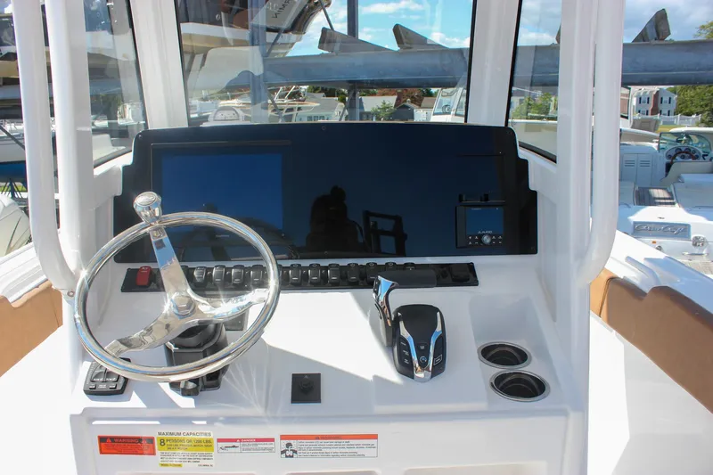 Slide: The Image of 2026 Sea Hunt Ultra 245 SE boat dashboard with steering wheel and controls. - 29