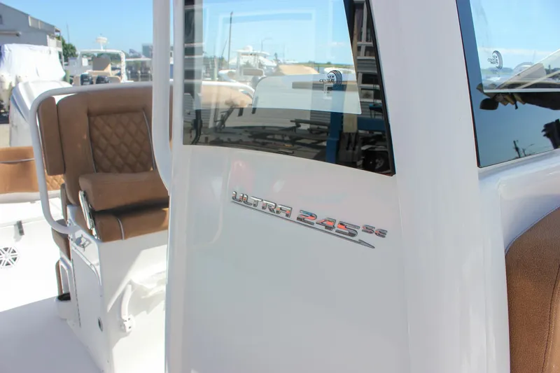 Slide: The Image of 2026 Sea Hunt Ultra 245 SE boat interior with brown seating and model emblem. - 3