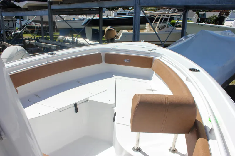 Slide: The Image of 2026 Sea Hunt Ultra 245 SE boat interior with brown seating and white deck. - 32