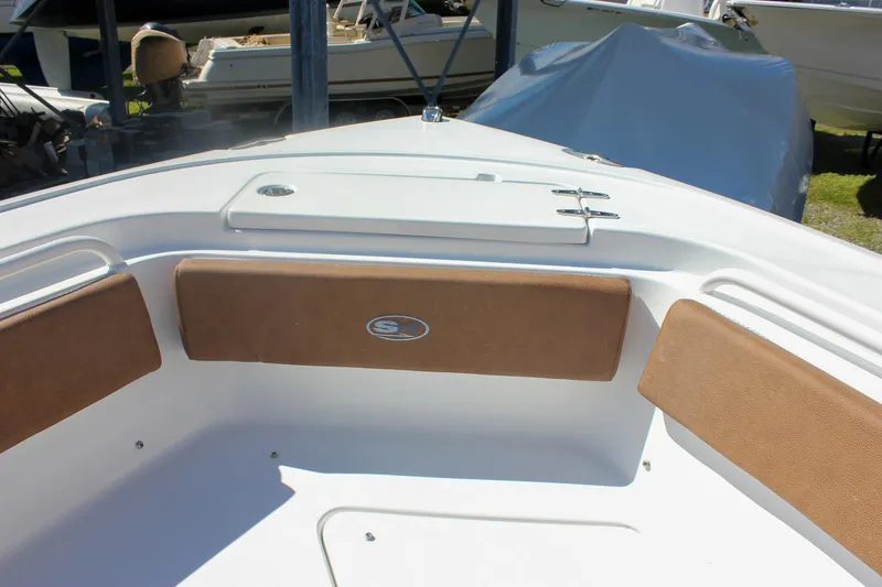 Slide: The Image of 2026 Sea Hunt Ultra 245 SE boat interior with cushioned seating and storage compartment. - 34