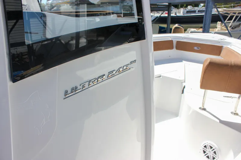 Slide: The Image of 2026 Sea Hunt Ultra 245 SE boat interior with seating and model emblem. - 36