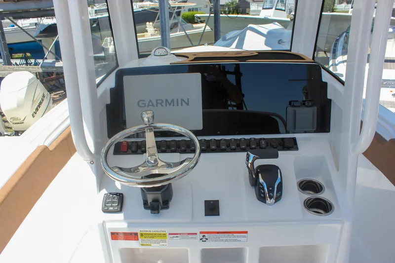 Slide: The Image of 2026 Sea Hunt Ultra 245 SE boat dashboard with Garmin display and steering wheel. - 4