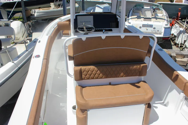 Slide: The Image of 2026 Sea Hunt Ultra 245 SE boat interior with tan seating and Garmin navigation system. - 5