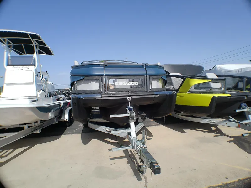 Slide: The Image of 2025 Sea-Doo 55SL boat on trailer, parked outdoors under clear blue sky. - 14