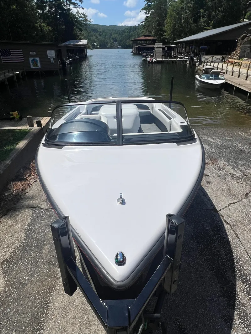 Slide: The Image of 1997 Correct Craft Ski Nautique 196 boat on trailer by a scenic lake. - 4