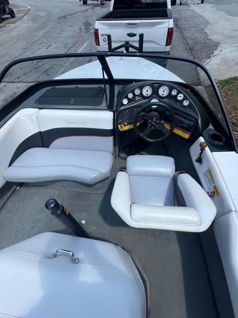 Slide: The Image of 1997 Correct Craft Ski Nautique 196 interior with white seating and dashboard controls. - 7