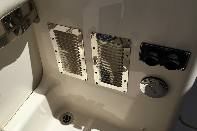 Slide: The Image of 2022 Grady-White Freedom 325 boat interior with engine flush controls and ventilation grilles. - 72