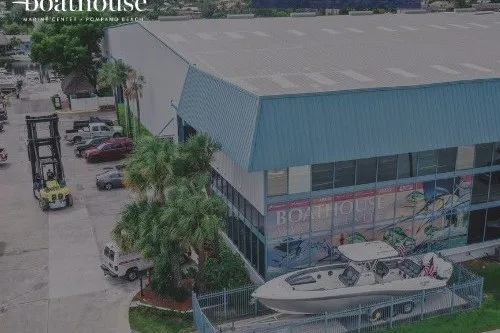 Slide: The Image of 2022 Grady-White Freedom 325 boat displayed outside a large boathouse facility. - 83