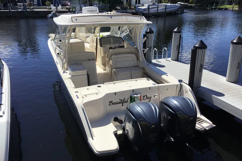 Slide: The Image of 2022 Grady-White Freedom 325 boat docked, featuring dual Yamaha engines and spacious seating. - 74