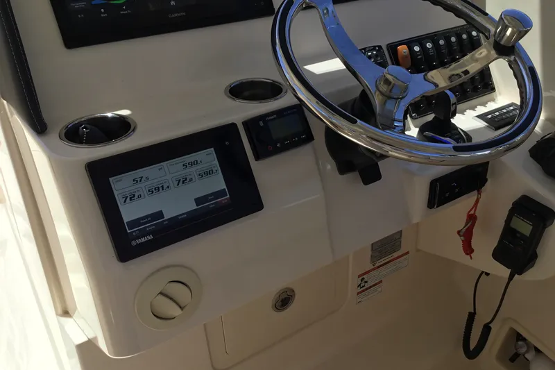 Slide: The Image of 2022 Grady-White Freedom 325 boat dashboard with steering wheel and digital display. - 73