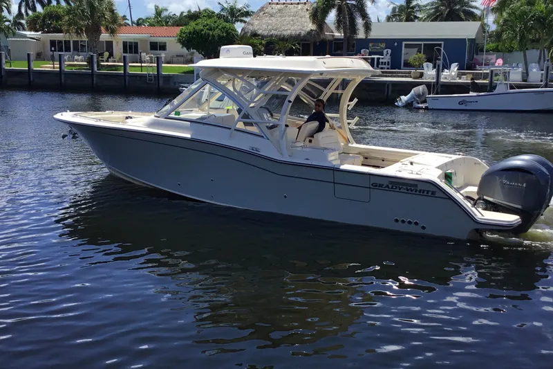 Slide: The Image of 2022 Grady-White Freedom 325 boat cruising on a sunny waterfront. - 19