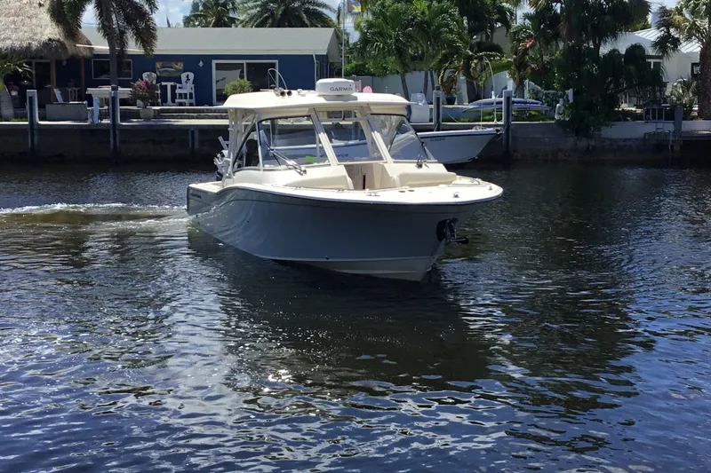 Slide: The Image of 2022 Grady-White Freedom 325 boat cruising on a sunny waterfront. - 13