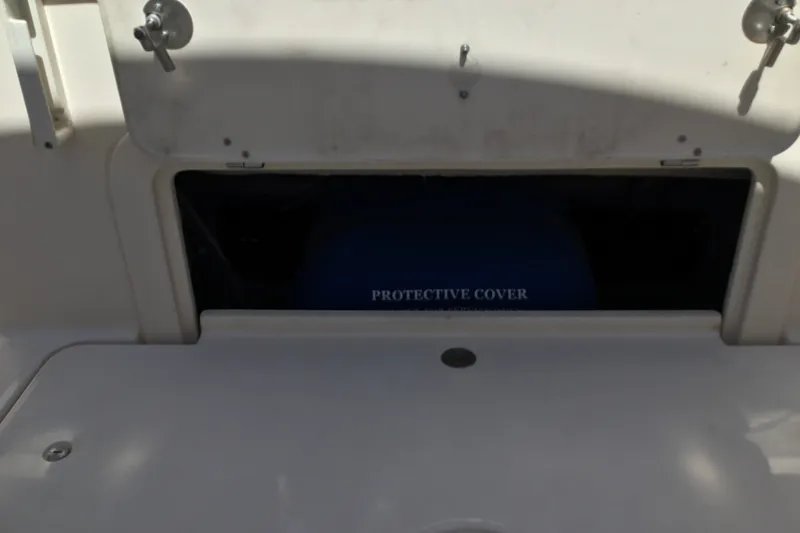 Slide: The Image of Open storage compartment on 2022 Grady-White Freedom 325 boat with protective cover. - 70