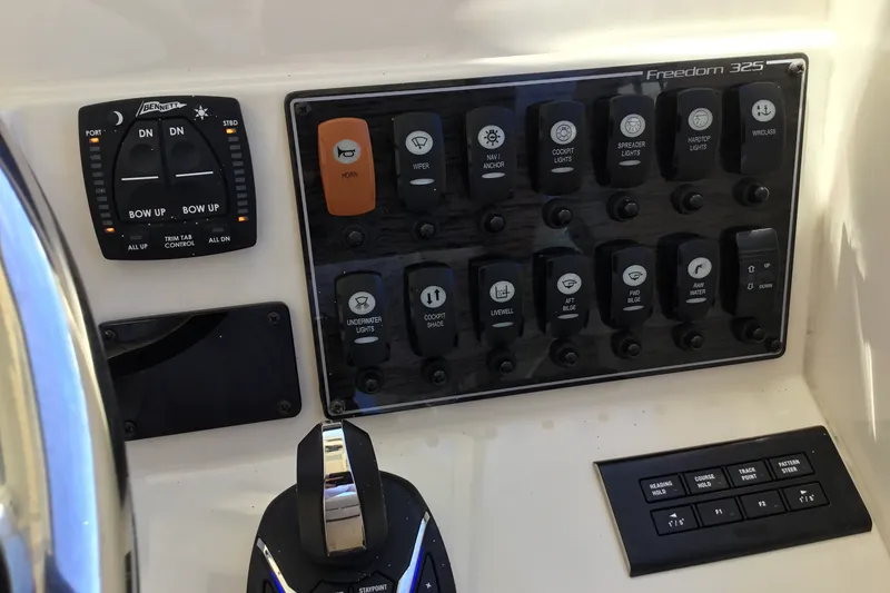 Slide: The Image of Control panel of 2022 Grady-White Freedom 325 boat with various switches and controls. - 54