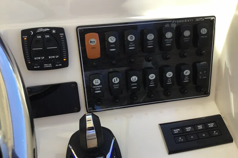 Slide: The Image of Control panel of 2022 Grady-White Freedom 325 boat with various switches and buttons. - 53