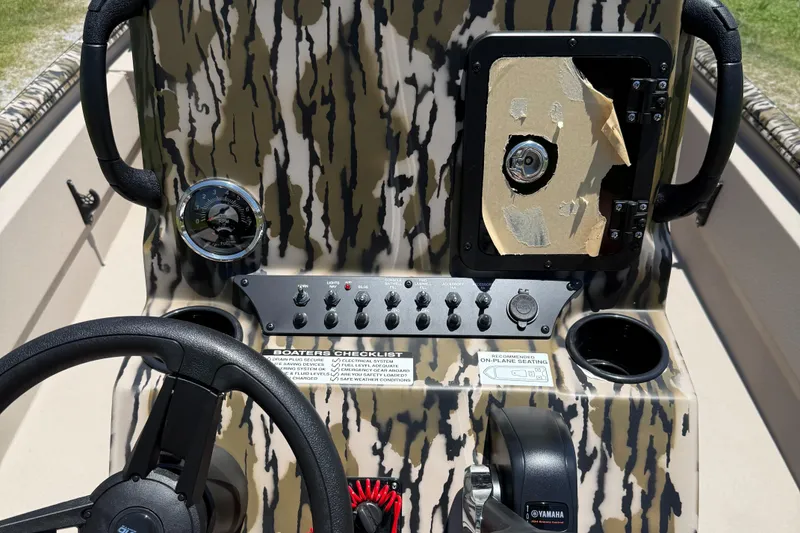 Slide: The Image of Control panel of 2026 Avid 20 ROGUE CC boat with camouflage design and steering wheel. - 4