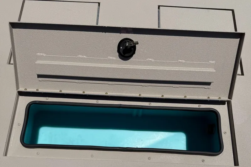 Slide: The Image of Open storage compartment on 2026 Avid 20 ROGUE CC boat, featuring a blue interior. - 7