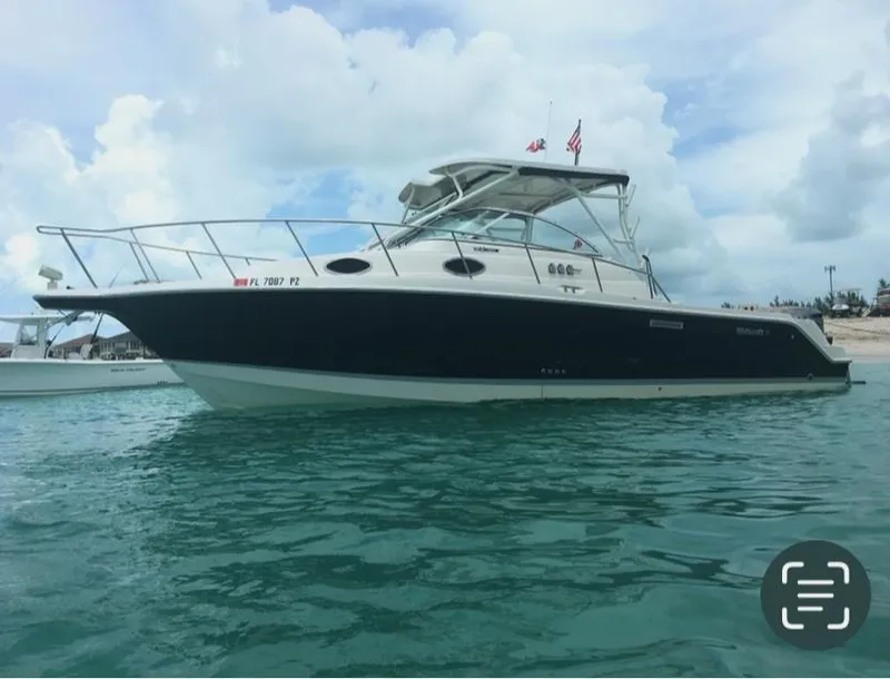 The Image of 2015 Wellcraft 290 Coastal boat on clear blue water under a cloudy sky. - 0