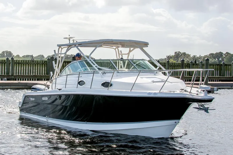 Slide: The Image of 2015 Wellcraft 290 Coastal boat cruising near a dock on a sunny day. - 1