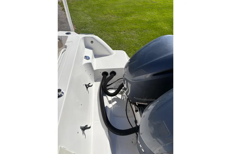 Slide: The Image of 2015 Wellcraft 290 Coastal boat with dual outboard motors, docked on grass. - 24