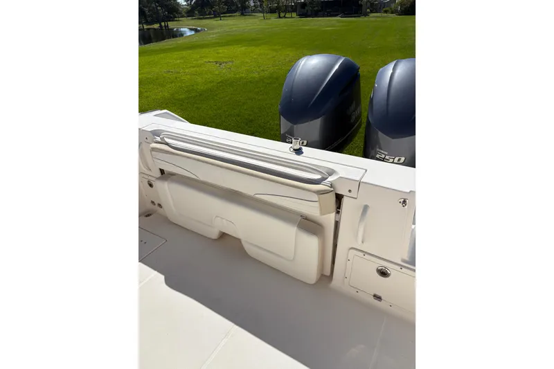 Slide: The Image of 2015 Wellcraft 290 Coastal boat with twin Yamaha 250 engines, docked on grassy shore. - 26