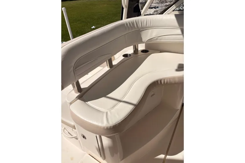 Slide: The Image of 2015 Wellcraft 290 Coastal boat interior with white cushioned seating and cup holders. - 30