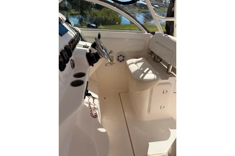 Slide: The Image of 2015 Wellcraft 290 Coastal boat interior with steering wheel and seating area. - 31