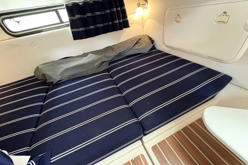 Slide: The Image of 2015 Wellcraft 290 Coastal cabin with striped cushions and wooden flooring. - 34