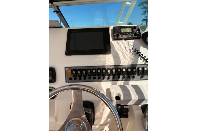 Slide: The Image of 2015 Wellcraft 290 Coastal helm with steering wheel, control panel, and navigation equipment. - 44