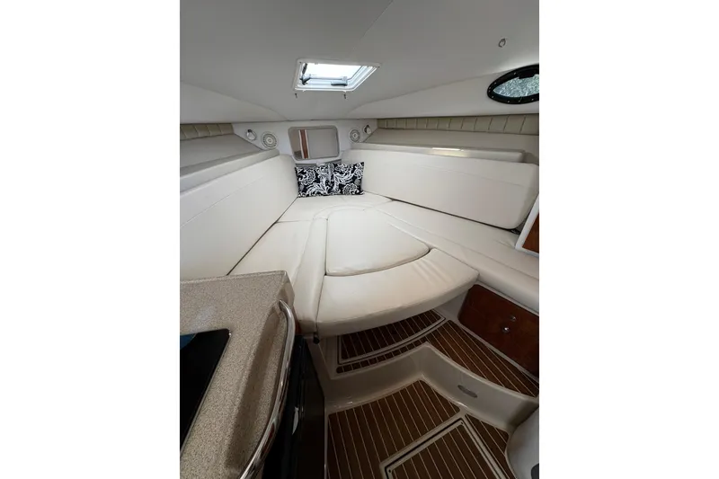Slide: The Image of 2015 Wellcraft 290 Coastal cabin interior with white seating and wood flooring. - 54