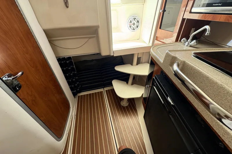 Slide: The Image of Interior of 2015 Wellcraft 290 Coastal boat with kitchenette and wooden flooring. - 57