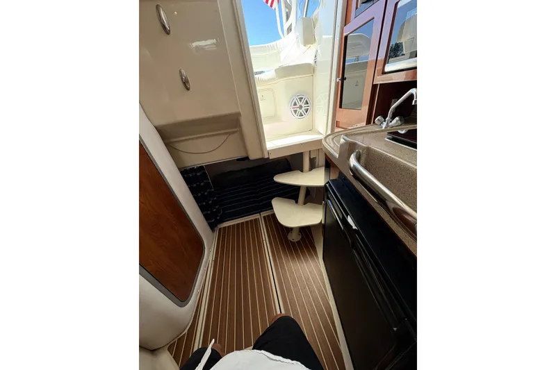 Slide: The Image of Interior of 2015 Wellcraft 290 Coastal boat with kitchenette and wooden flooring. - 58