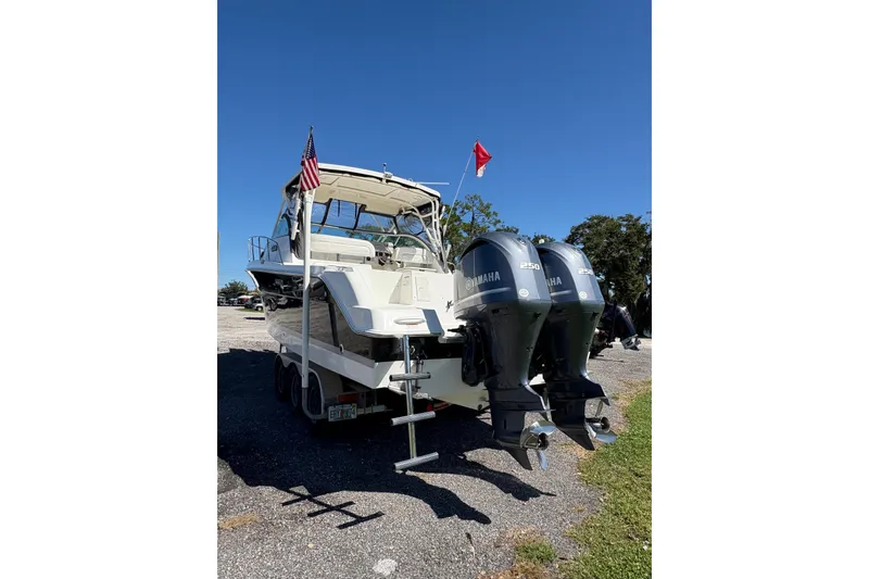 Slide: The Image of 2015 Wellcraft 290 Coastal boat with dual Yamaha engines, parked on a trailer. - 63