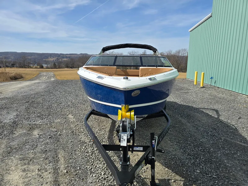 Slide: The Image of 2025 Four Winns H1 boat on trailer, parked on gravel near a green building. - 10