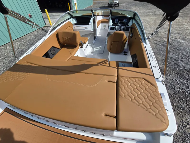 Slide: The Image of 2025 Four Winns H1 boat interior with tan leather seating and modern dashboard. - 11