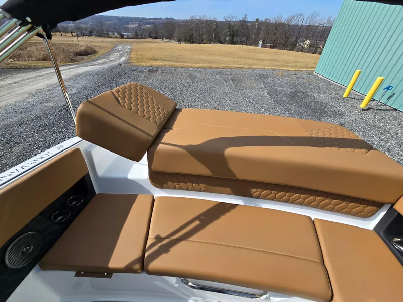 Slide: The Image of 2025 Four Winns H1 boat interior with tan leather seating and scenic outdoor view. - 13