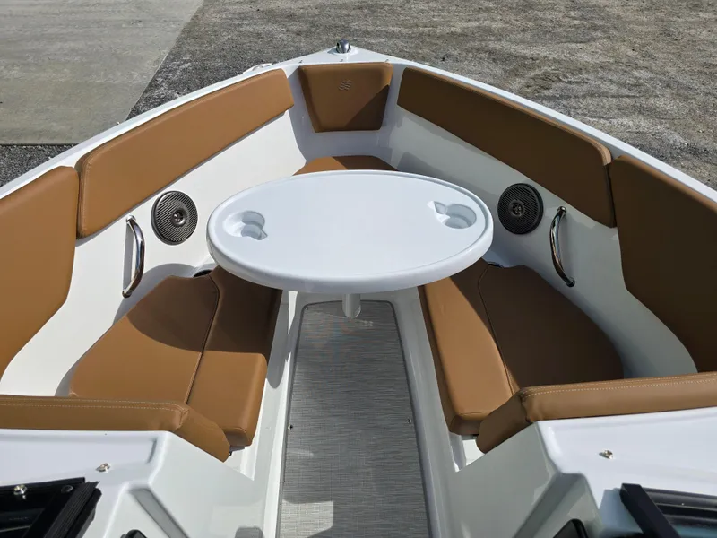 Slide: The Image of 2025 Four Winns H1 boat interior with brown seating and a white table. - 25