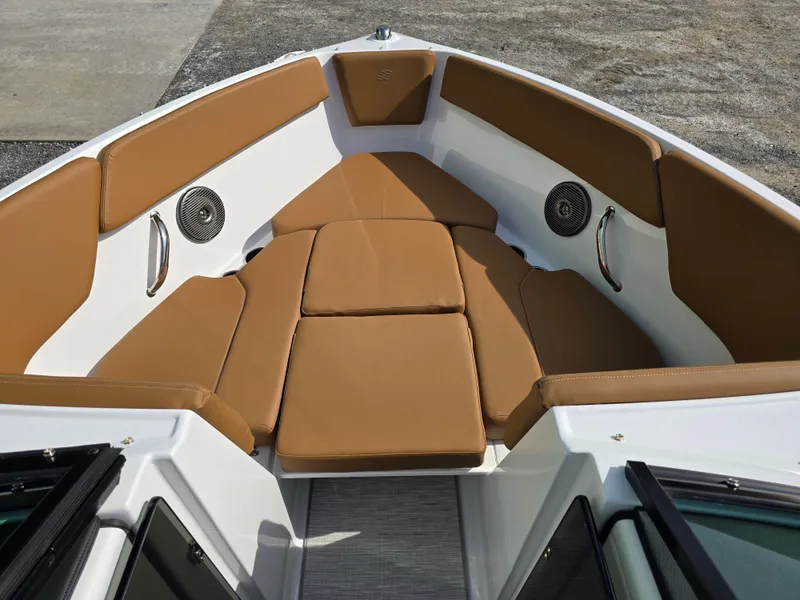 Slide: The Image of 2025 Four Winns H1 boat interior with tan cushioned seating and stainless steel accents. - 26