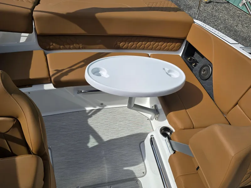 Slide: The Image of Luxurious seating area on 2025 Four Winns H1 boat with tan upholstery and a white table. - 27