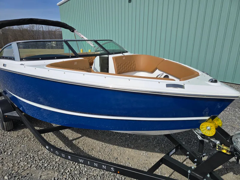 Slide: The Image of 2025 Four Winns H1 boat with blue hull and tan interior on trailer. - 3