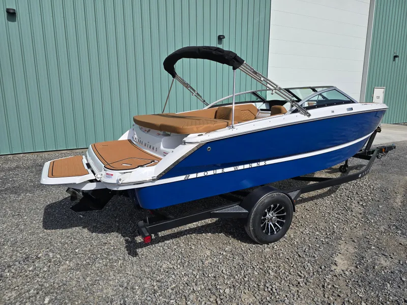 Slide: The Image of 2025 Four Winns H1 boat with blue hull and tan interior on a trailer. - 4