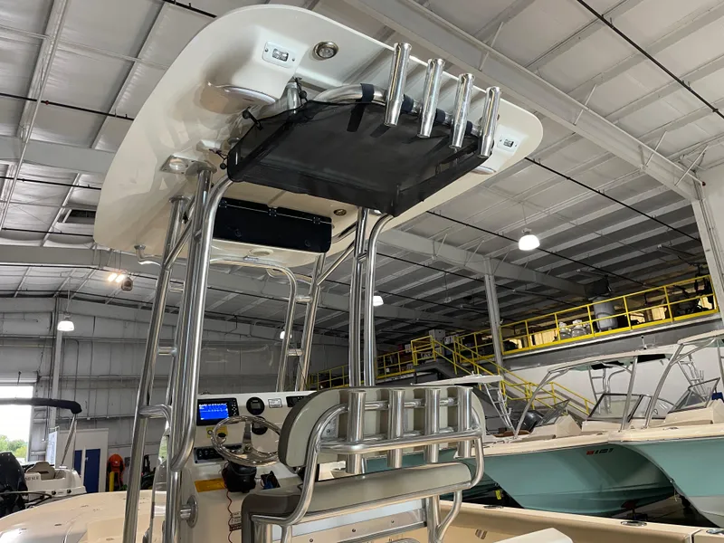 Slide: The Image of 2021 Key West 210 Bay Reef boat interior with T-top and rod holders in a showroom. - 13