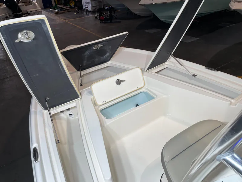 Slide: The Image of 2021 Key West 210 Bay Reef boat interior with open storage compartments. - 19