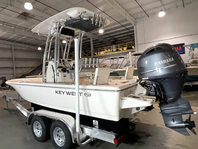 Slide: The Image of 2021 Key West 210 Bay Reef boat with Yamaha engine in a warehouse setting. - 2