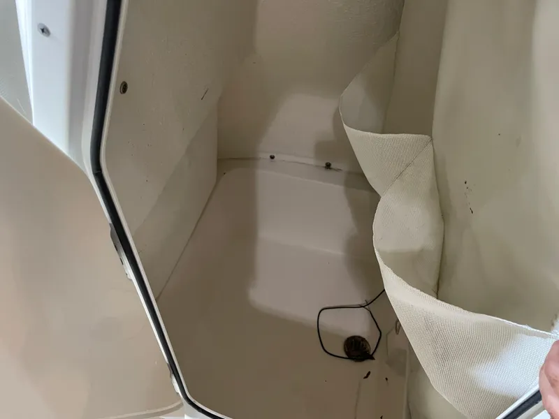 Slide: The Image of 2021 Key West 210 Bay Reef storage compartment interior with white lining and wiring. - 25