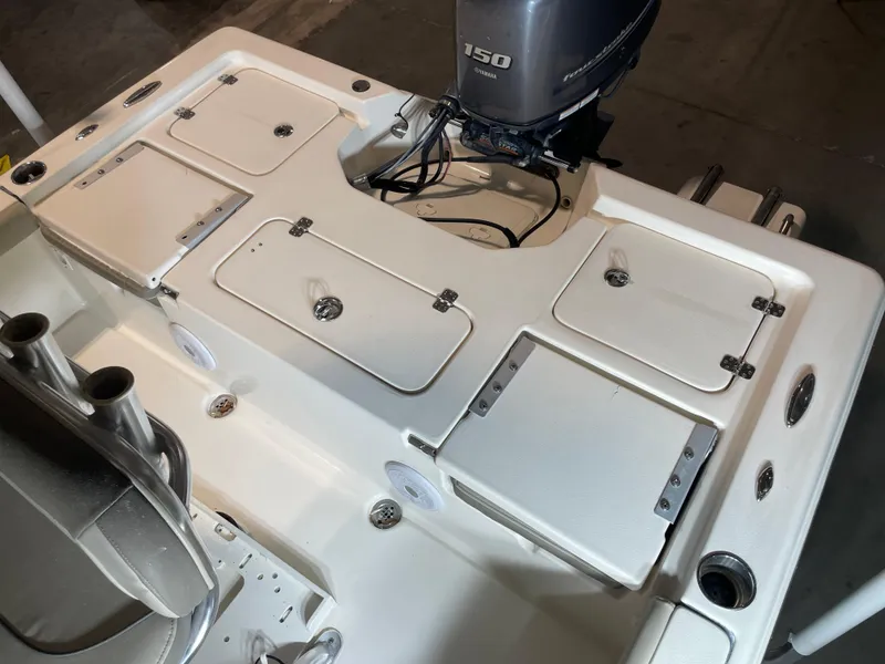 Slide: The Image of 2021 Key West 210 Bay Reef boat deck with Yamaha 150 engine, storage compartments, and rod holders. - 34