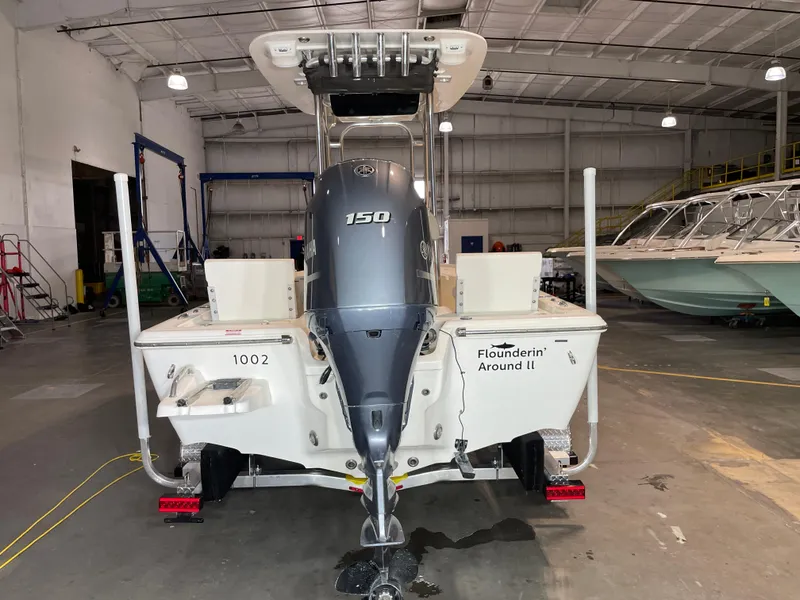 Slide: The Image of 2021 Key West 210 Bay Reef boat in a warehouse, featuring a Yamaha 150 engine. - 7