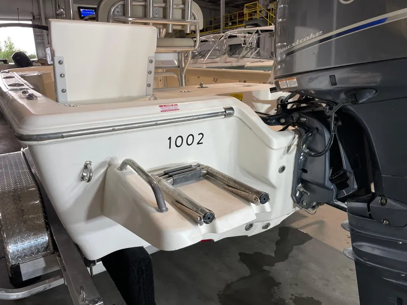 Slide: The Image of 2021 Key West 210 Bay Reef boat with outboard motor in a garage setting. - 8