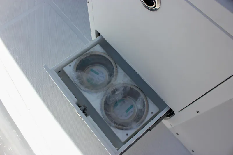 Slide: The Image of 2026 Sea Hunt Ultra 265 SE boat storage compartment with built-in cup holders. - 12